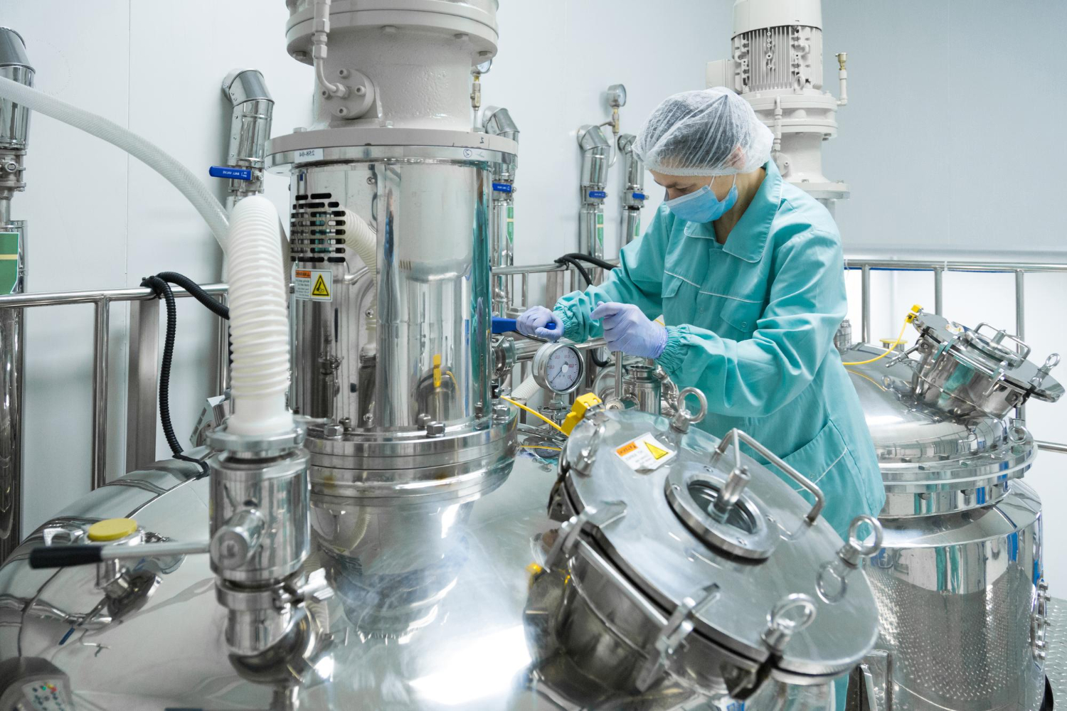 Profissional operando equipamentos industriais em fábrica terceirizada de cosméticos.